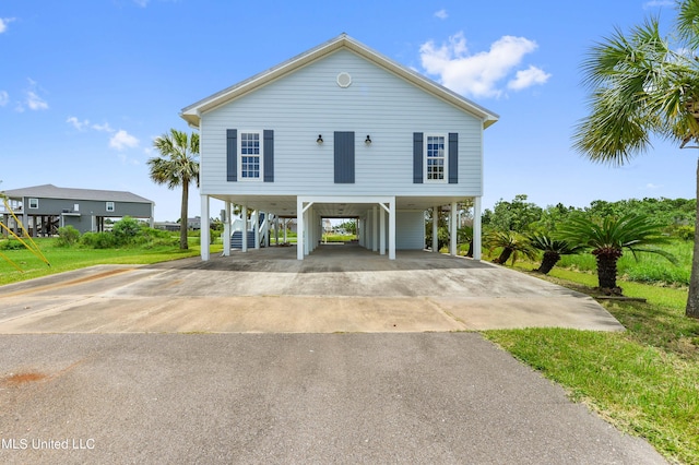 beach home featuring a front yard and a carport