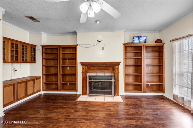 unfurnished living room with visible vents, a fireplace, crown molding, and dark wood-style flooring