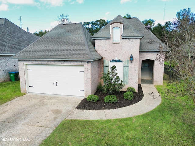 french country style house featuring a garage and a front yard