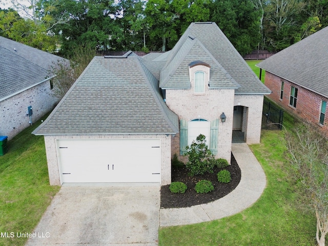 french country inspired facade with a front yard and a garage