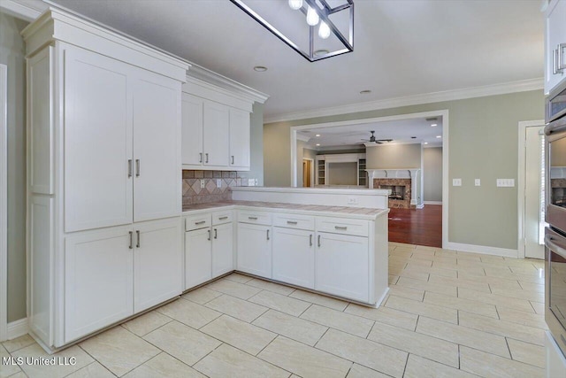 kitchen with tasteful backsplash, white cabinetry, and crown molding