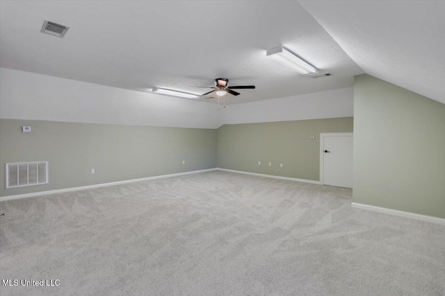 additional living space with ceiling fan, lofted ceiling, and light carpet