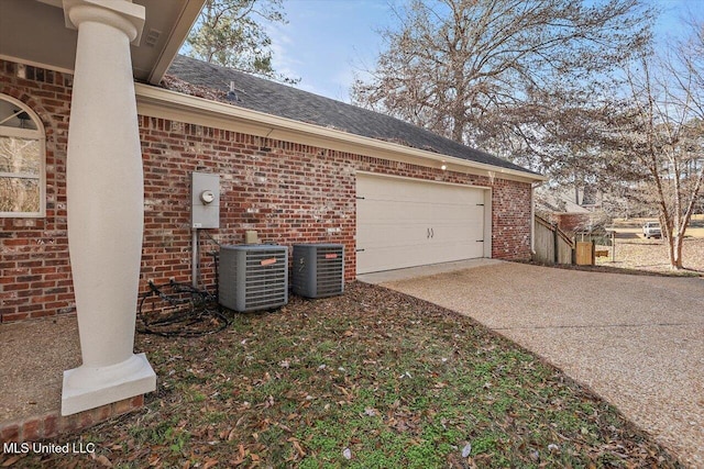 view of side of home featuring central AC unit and a garage