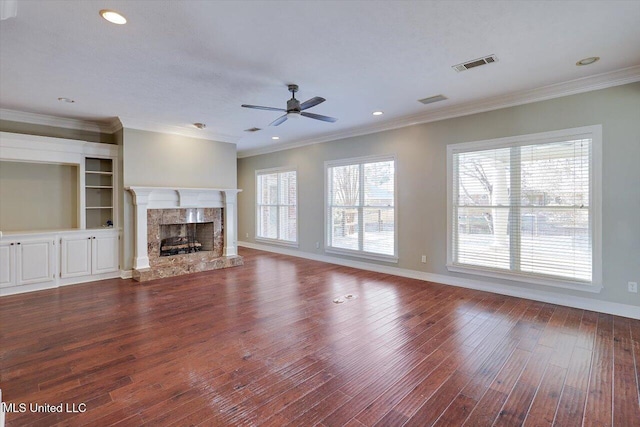 unfurnished living room featuring a high end fireplace, wood-type flooring, and ornamental molding