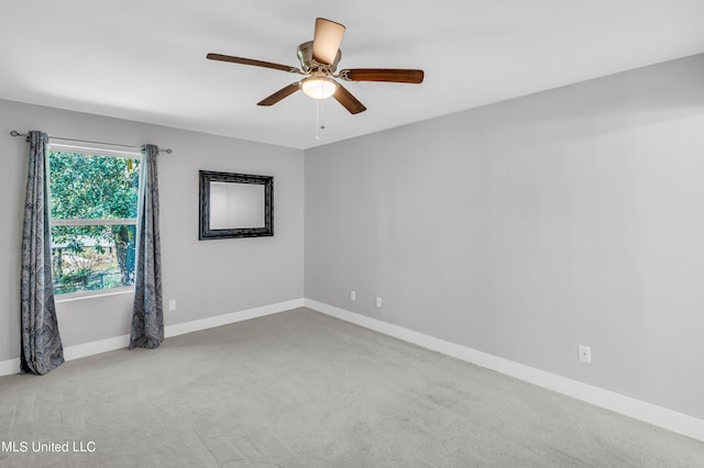 carpeted spare room with ceiling fan