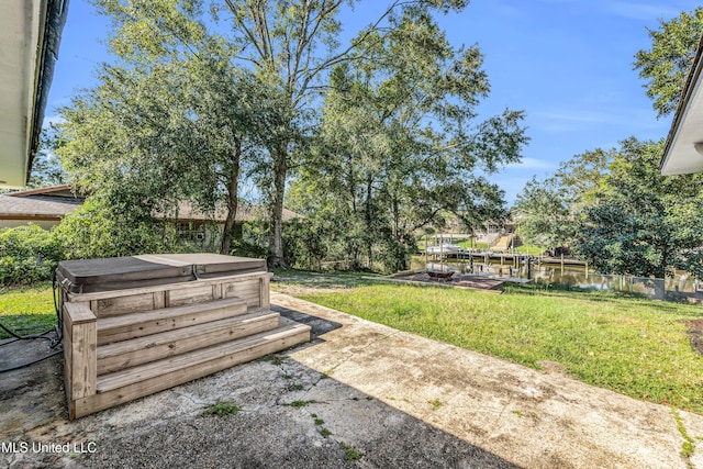 view of yard featuring a hot tub and a water view