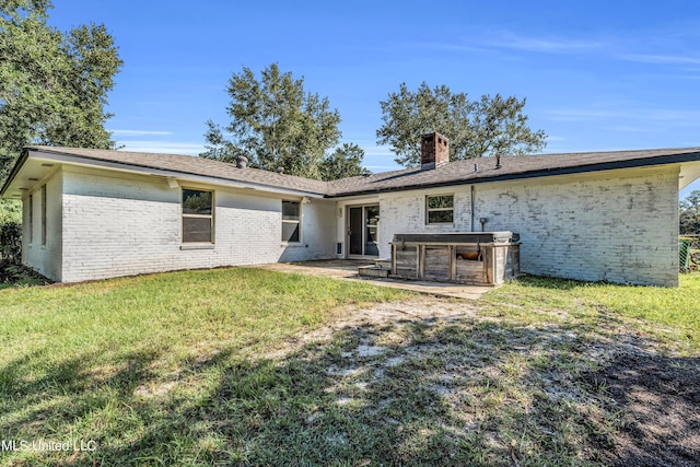 rear view of property featuring a patio and a lawn