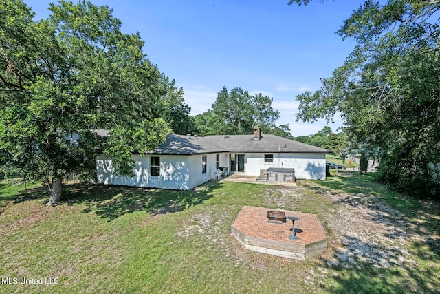 back of property featuring a patio area and a lawn