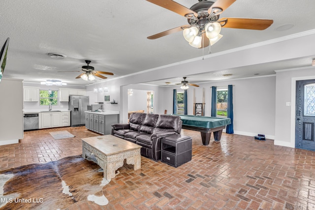 living room featuring sink, crown molding, billiards, a textured ceiling, and ceiling fan