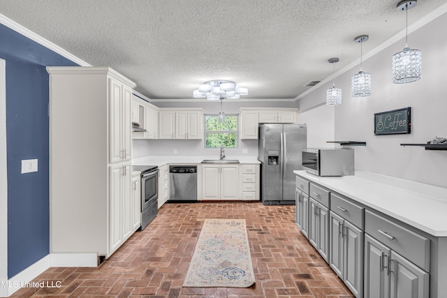 kitchen featuring crown molding, white cabinetry, stainless steel appliances, and sink