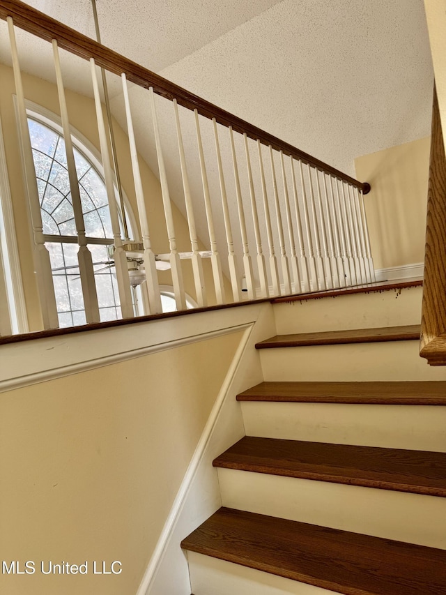 stairs with a textured ceiling