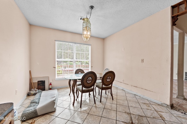 224 Clarence Ave, Pass Christian, MS 39571 - dining space with a textured ceiling, baseboards, and light tile patterned flooring