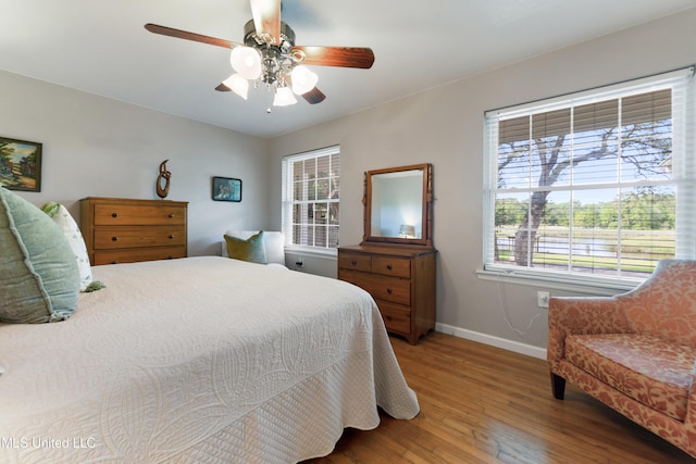2508 Orrell Dr, Gautier, MS 39553 - bedroom with baseboards, wood finished floors, multiple windows, and ceiling fan