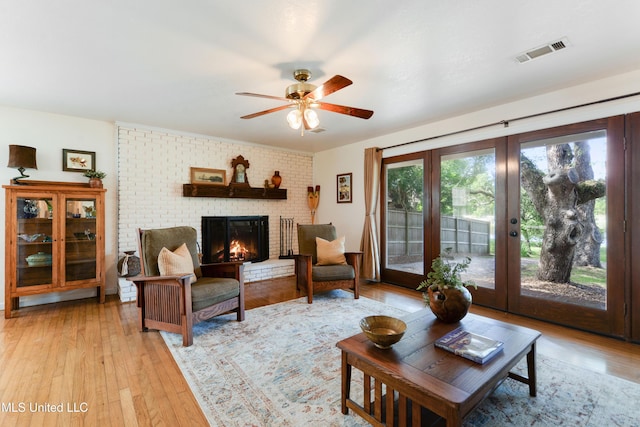 2508 Orrell Dr, Gautier, MS 39553 - living room with light wood-type flooring, ceiling fan, a fireplace, and french doors