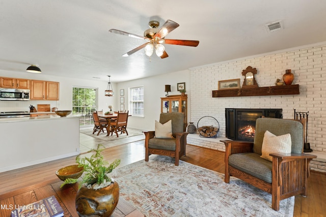 2508 Orrell Dr, Gautier, MS 39553 - living room with light wood-type flooring, ceiling fan, and a brick fireplace