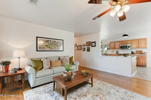 2508 Orrell Dr, Gautier, MS 39553 - living room featuring light wood-style floors, a ceiling fan, and baseboards
