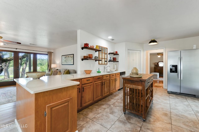 2508 Orrell Dr, Gautier, MS 39553 - kitchen featuring appliances with stainless steel finishes, open shelves, a ceiling fan, a sink, and open floor plan