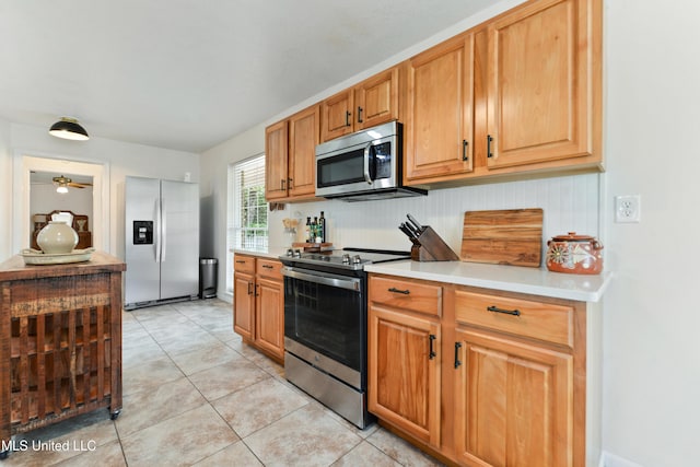 2508 Orrell Dr, Gautier, MS 39553 - kitchen with stainless steel appliances, light countertops, light tile patterned flooring, and ceiling fan