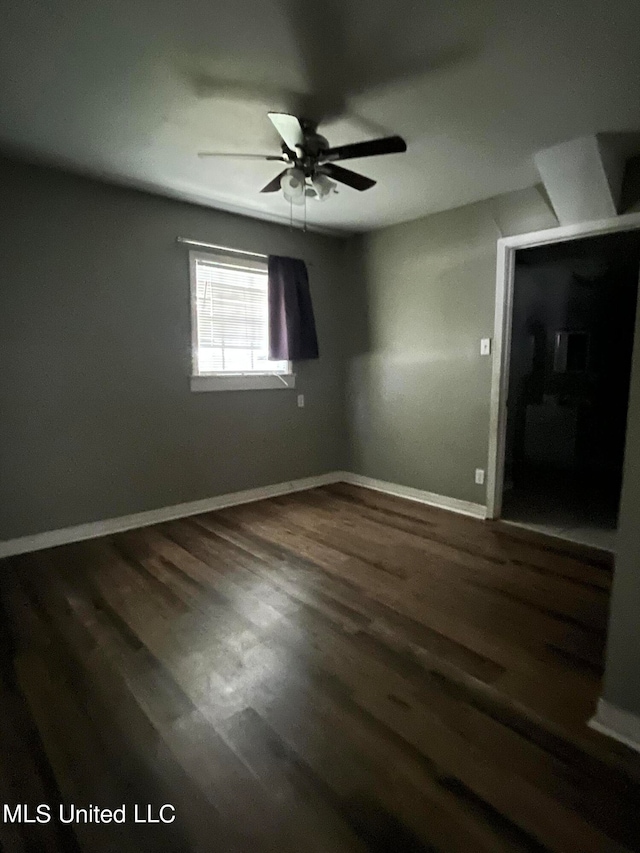 spare room with dark hardwood / wood-style floors and ceiling fan