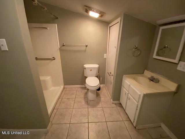 bathroom featuring tile patterned flooring, vanity, and toilet