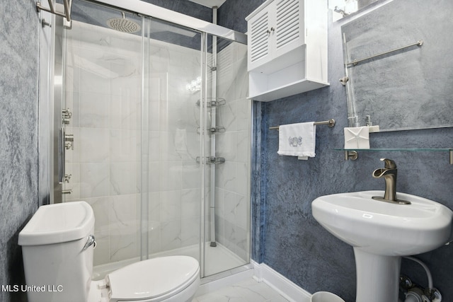 bathroom with a shower with door and toilet