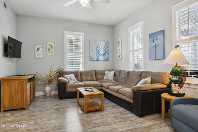 living room featuring ceiling fan, a healthy amount of sunlight, and light wood-type flooring