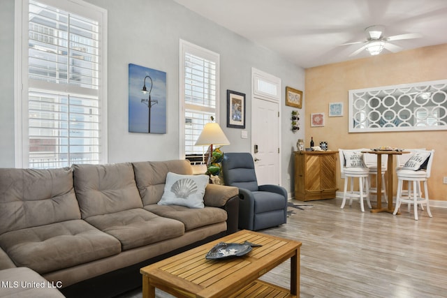 living room featuring light hardwood / wood-style flooring and ceiling fan