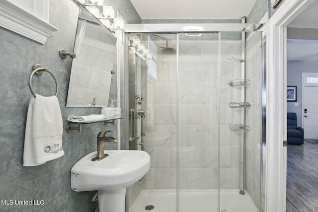 bathroom with a shower with door, hardwood / wood-style flooring, and sink