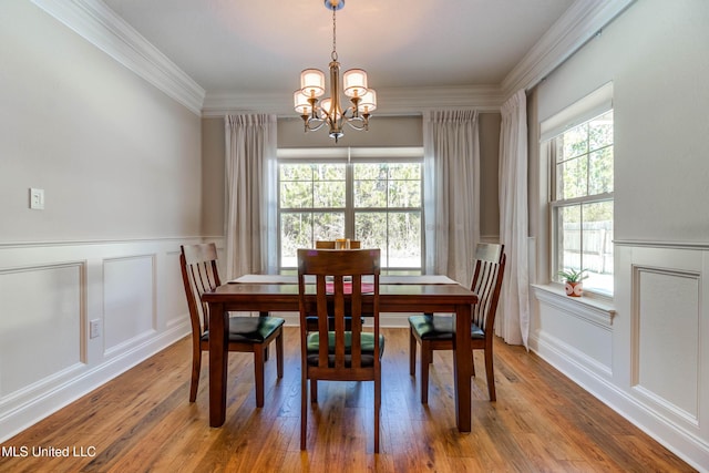 dining area featuring ornamental molding, hardwood / wood-style floors, and a notable chandelier