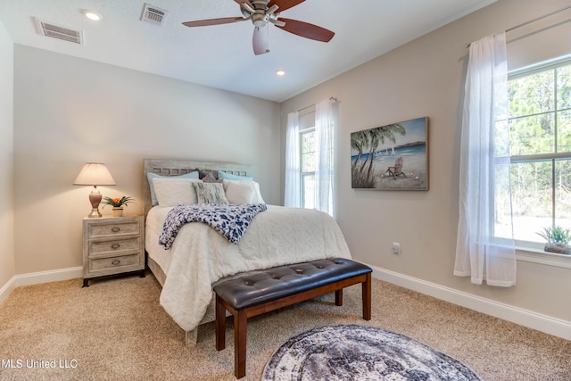 carpeted bedroom featuring ceiling fan and multiple windows