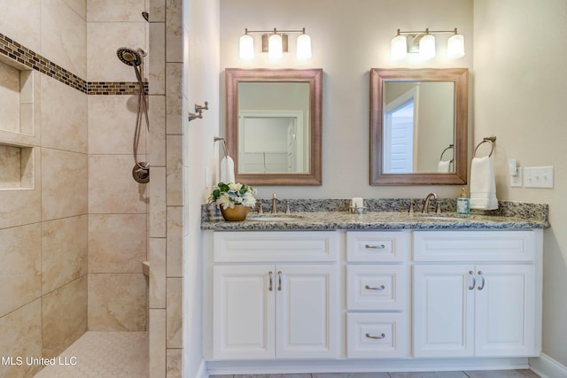 bathroom featuring tiled shower and vanity