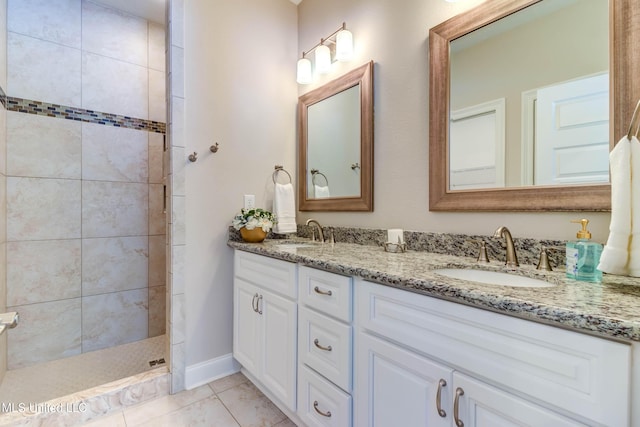 bathroom with tile patterned flooring, vanity, and a tile shower