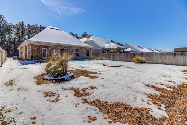 view of snow covered back of property