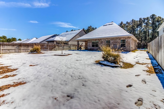 view of snow covered back of property