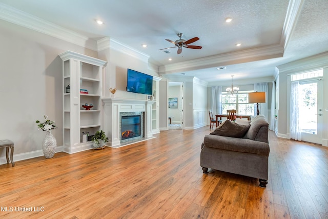 living room featuring crown molding, a high end fireplace, a textured ceiling, and light hardwood / wood-style flooring