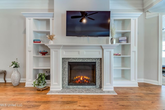 living room featuring wood-type flooring, a fireplace, and built in features