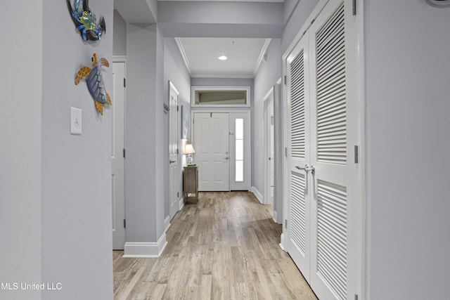 hall featuring light wood-type flooring and crown molding