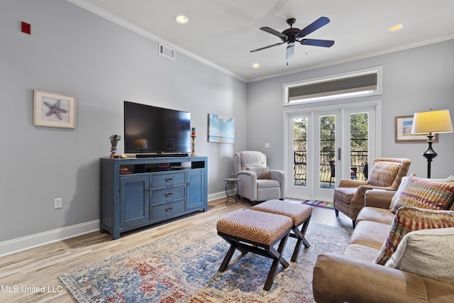 living room with light wood-type flooring, ceiling fan, and ornamental molding