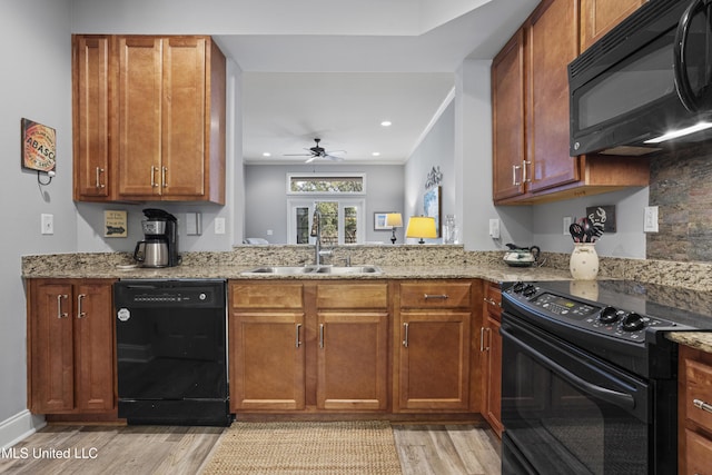 kitchen featuring black appliances, light hardwood / wood-style floors, sink, and french doors