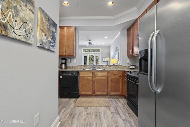 kitchen featuring black appliances, sink, crown molding, ceiling fan, and light stone counters