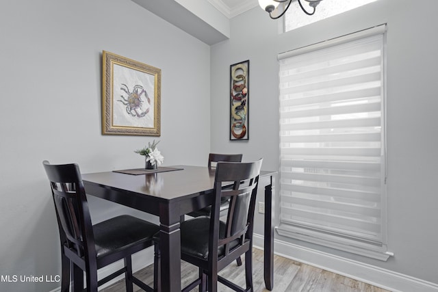 dining room featuring light hardwood / wood-style flooring, an inviting chandelier, and ornamental molding