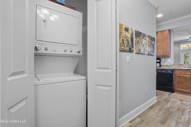 laundry area with ceiling fan, light wood-type flooring, stacked washer and clothes dryer, and ornamental molding