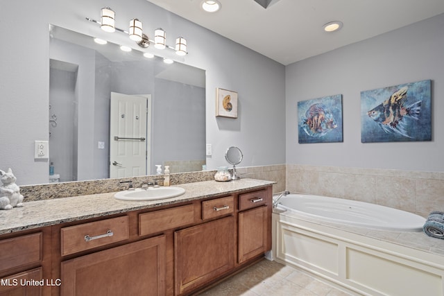 bathroom featuring tile patterned flooring, vanity, and a bath