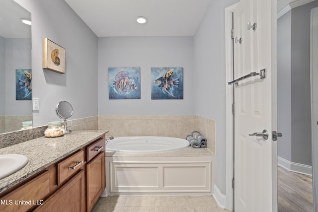 bathroom featuring a bathtub, vanity, and tile patterned flooring