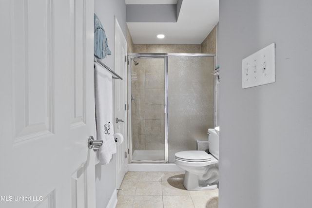 bathroom with tile patterned floors, a shower with door, and toilet