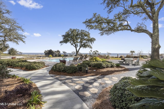 view of home's community with a water view and a swimming pool