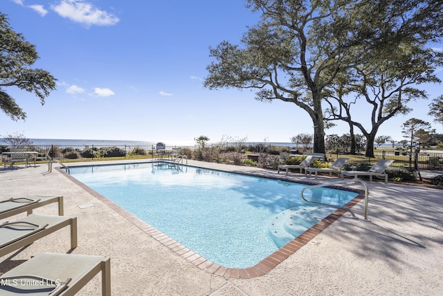 view of pool featuring a water view and a patio