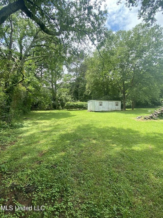 210 Colonial Cir, Jackson, MS 39211 - view of grassy yard with an outbuilding and a storage shed