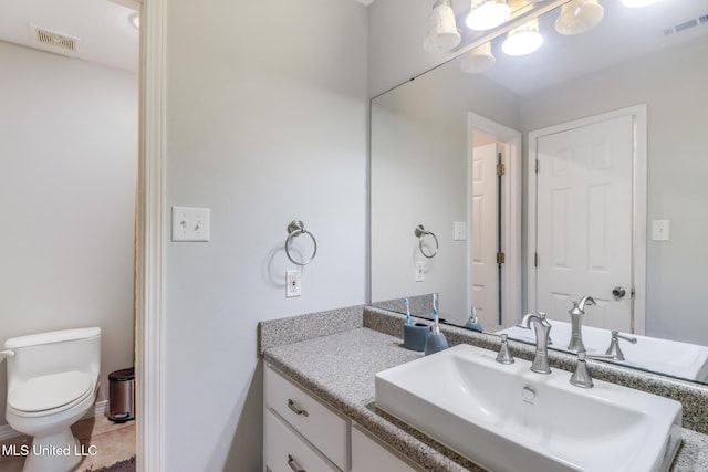 bathroom featuring visible vents, toilet, and vanity