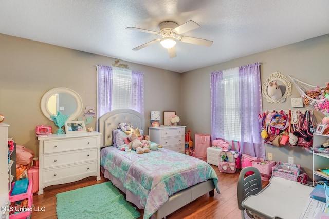 bedroom featuring a textured ceiling, a ceiling fan, and wood finished floors